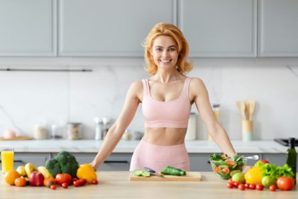 Fitness enthusiast with veggies in kitchen