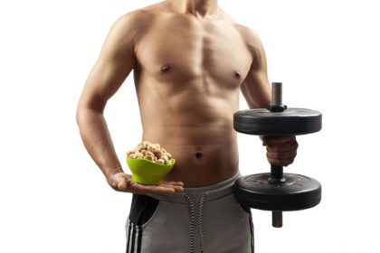 muscular man with soy chunk protein food and dumbbell